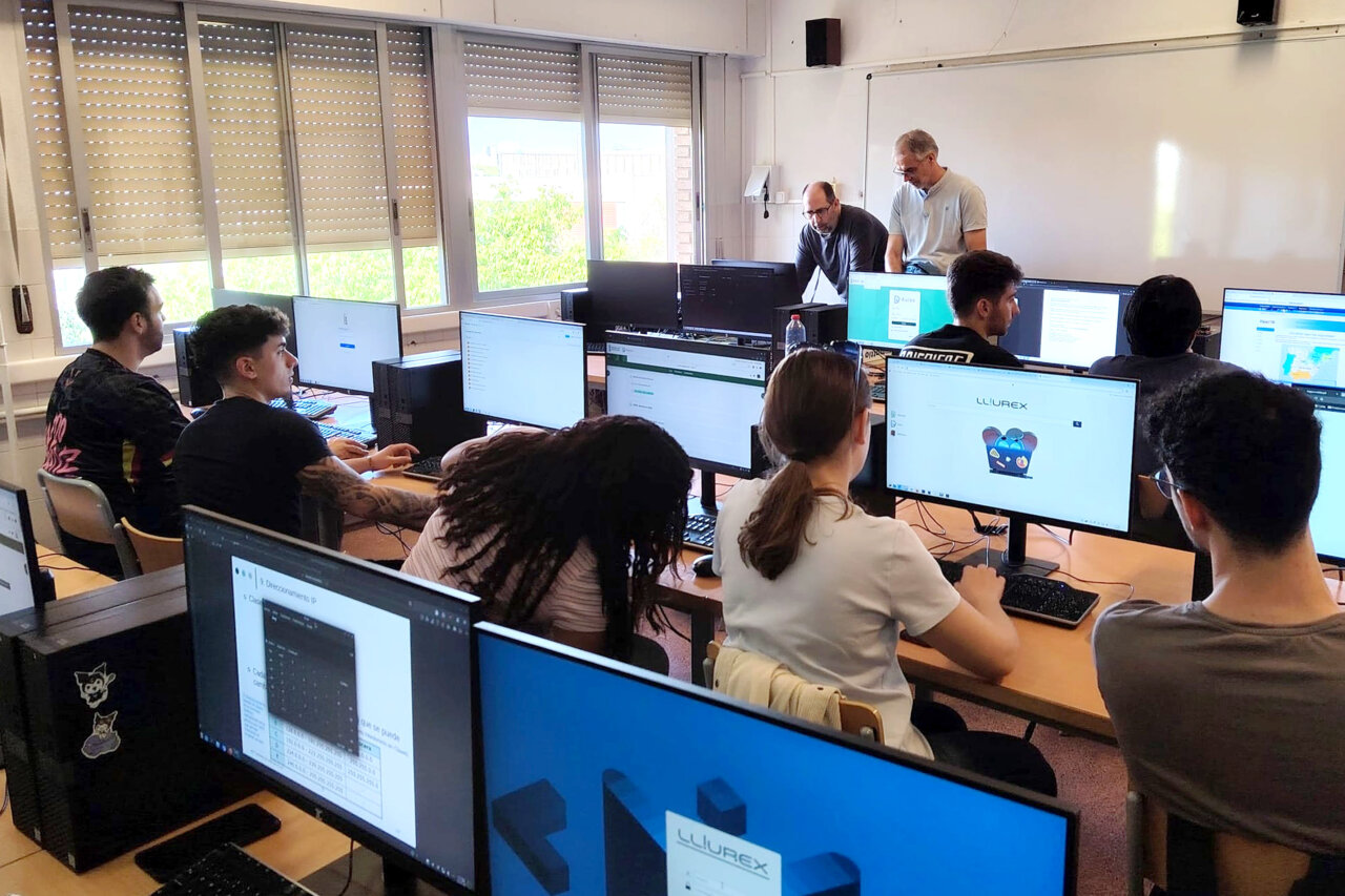 Estudiantes en clase de computación usando ordenadores en Paiporta