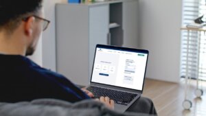 Persona usando una computadora portátil para acceder a servicios de Aigües de l'Horta