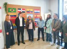 Presentación de proyectos en Benetússer con varias personas y banderas de diferentes países.