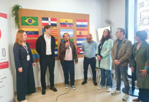 Presentación de proyectos en Benetússer con varias personas y banderas de diferentes países.