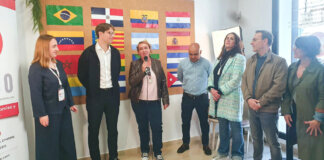 Presentación de proyectos en Benetússer con varias personas y banderas de diferentes países.