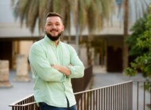 Enric Valls sonríe en un entorno urbano con palmeras.