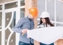 Dos profesionales revisando planos de construcción en una obra