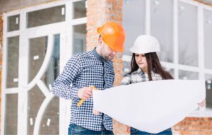 Dos profesionales revisando planos de construcción en una obra