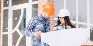 Dos profesionales revisando planos de construcción en una obra