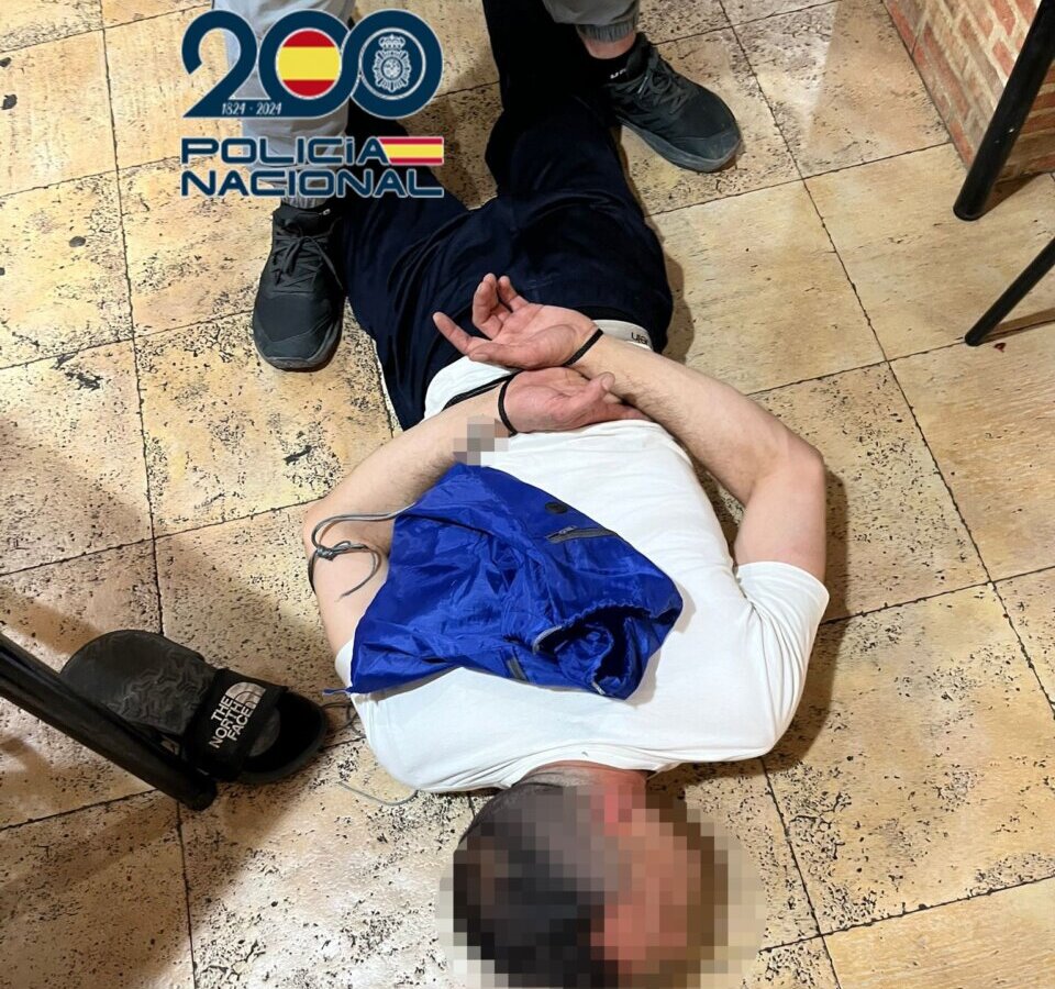 Sospechoso detenido por la policía en el suelo con las manos atadas
