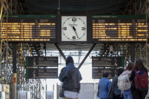 Pantalla de información en estación de tren con horarios y retrasos