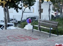 Grafiti de símbolo en el suelo junto a un banco en un parque.