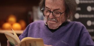 Josep Piera leyendo un libro en un evento literario