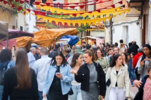 Multitud de personas en la feria asociativa de Benetússer con decoraciones coloridas