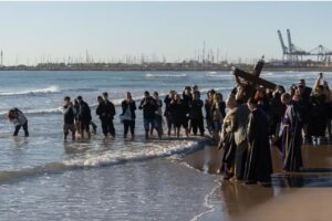 Ceremonia en la playa con imágenes religiosas y fieles rindiendo homenaje