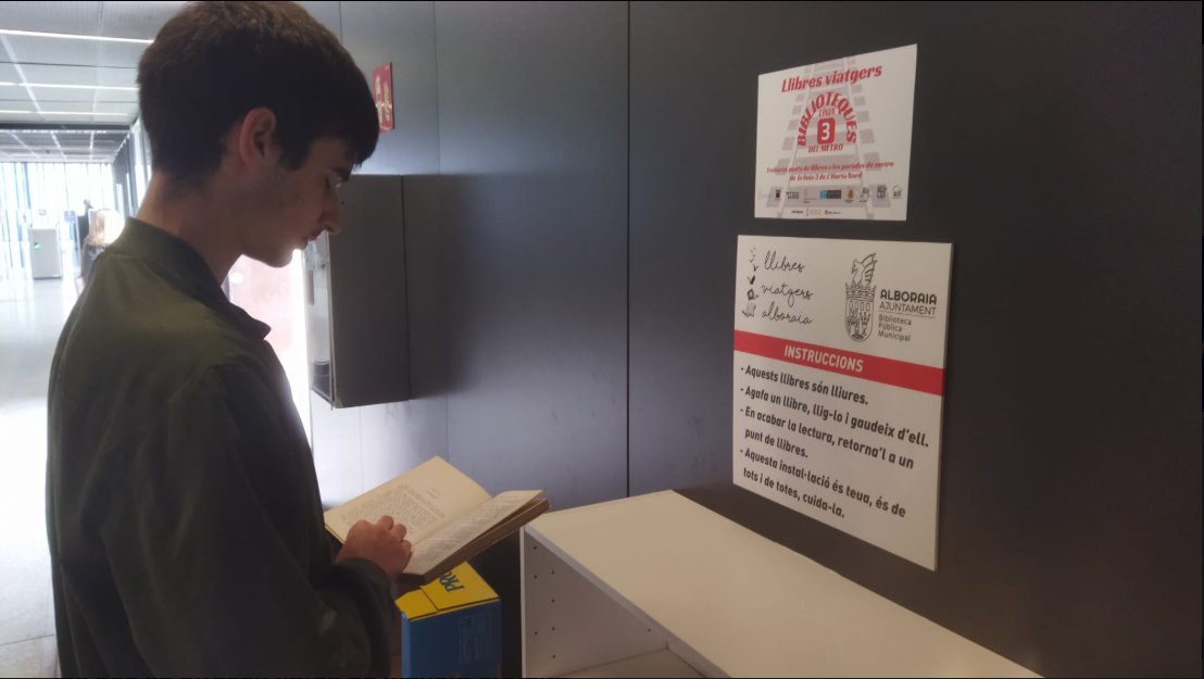 Joven leyendo un libro en una estación de metro de l'Horta Nord