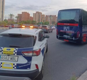 Policía local de Valencia inmovilizando un autobús en la calle.