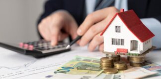Persona calculando inversiones inmobiliarias con casa y dinero