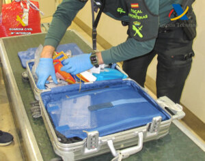 Agente de la Guardia Civil revisando maleta en aeropuerto de Valencia