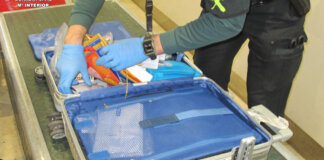 Agente de la Guardia Civil revisando maleta en aeropuerto de Valencia