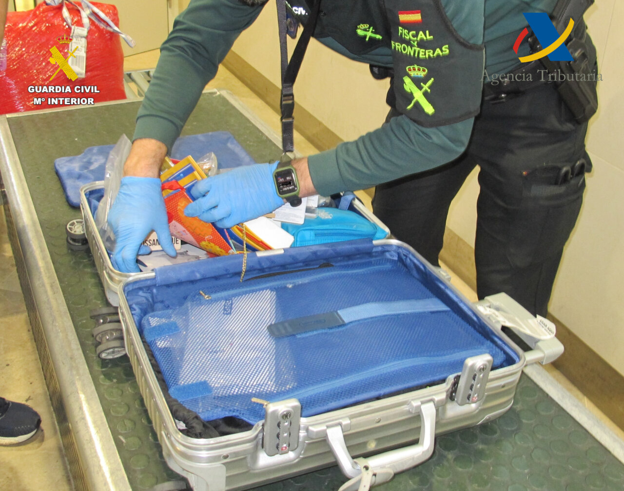 Agente de la Guardia Civil revisando maleta en aeropuerto de Valencia
