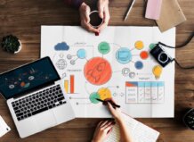 Mesa de trabajo con laptop, gráficos y notas sobre marketing digital