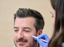Hombre recibiendo tratamiento estético con botox en el rostro