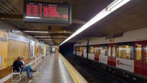 Estación de metro en Valencia con tren y pantalla de horarios