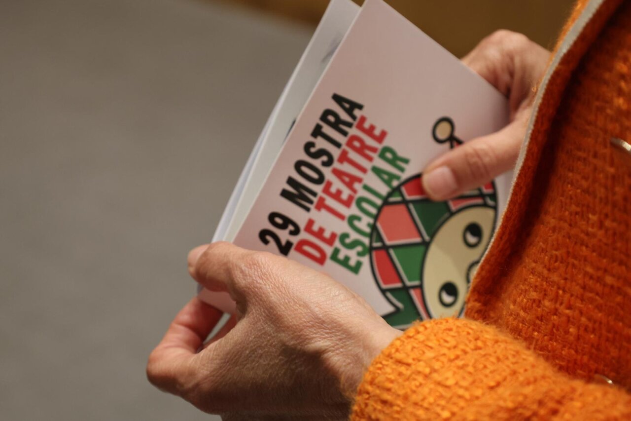 Persona sosteniendo un programa de la 29ª Mostra de Teatre Escolar