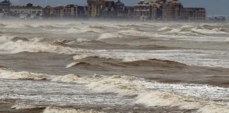 Vista de la niebla de advección sobre el mar y edificios costeros.
