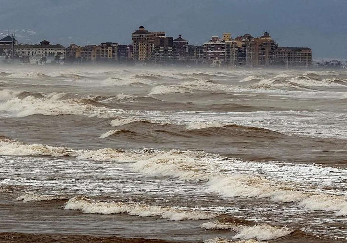 Vista de la niebla de advección sobre el mar y edificios costeros.