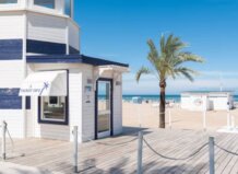 Oficina de información turística junto a la playa con palmera