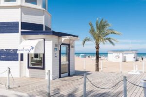 Oficina de información turística junto a la playa con palmera