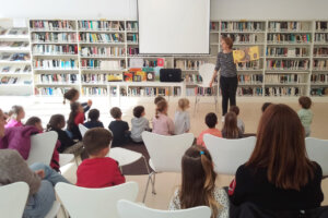 Niños escuchando un cuentacuentos en una biblioteca