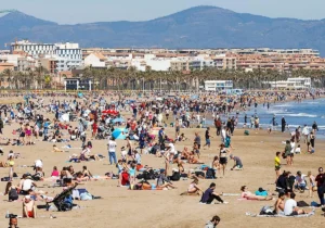 Playa de la Malvarrosa llena de turistas en un día soleado