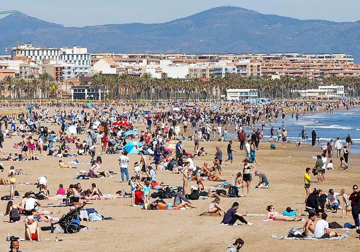 Playa de la Malvarrosa llena de turistas en un día soleado