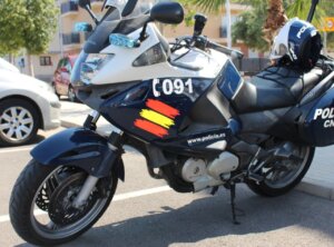 Moto de la policía nacional con luces y casco en la carretera