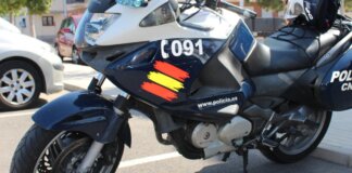 La Policía Nacional detiene a 6 hombres en València por una pelea masiva con lanzamiento de piedras Moto de la policía nacional con luces y casco en la carretera