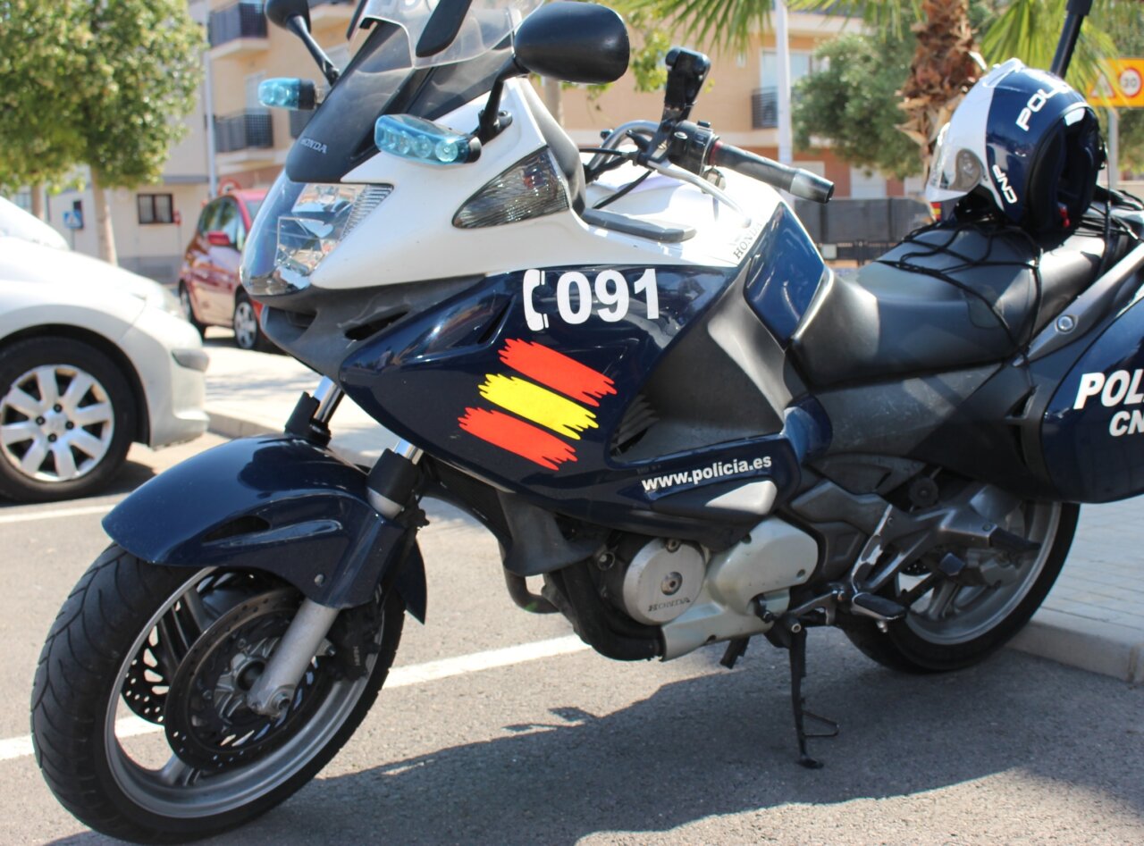 Moto de la policía nacional con luces y casco en la carretera