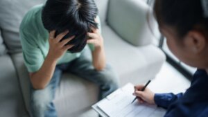 Joven con las manos en la cabeza durante una sesión de apoyo psicológico