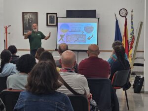 Reunión sobre huertos comunitarios en Foios con participantes y presentador