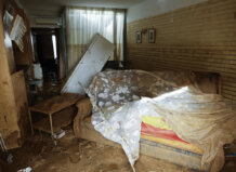 Interior de una vivienda afectada por la DANA con muebles dañados y barro