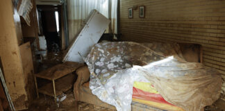 Interior de una vivienda afectada por la DANA con muebles dañados y barro