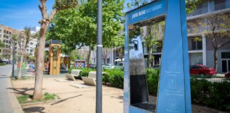 Fuente de agua potable en un parque de Torrent con árboles y juegos infantiles