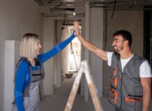 Dos trabajadores de la construcción celebrando en un espacio en reforma