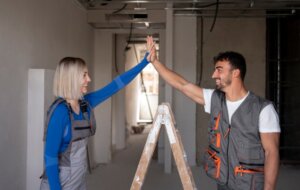 Dos trabajadores de la construcción celebrando en un espacio en reforma