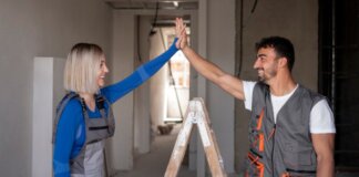 Dos trabajadores de la construcción celebrando en un espacio en reforma