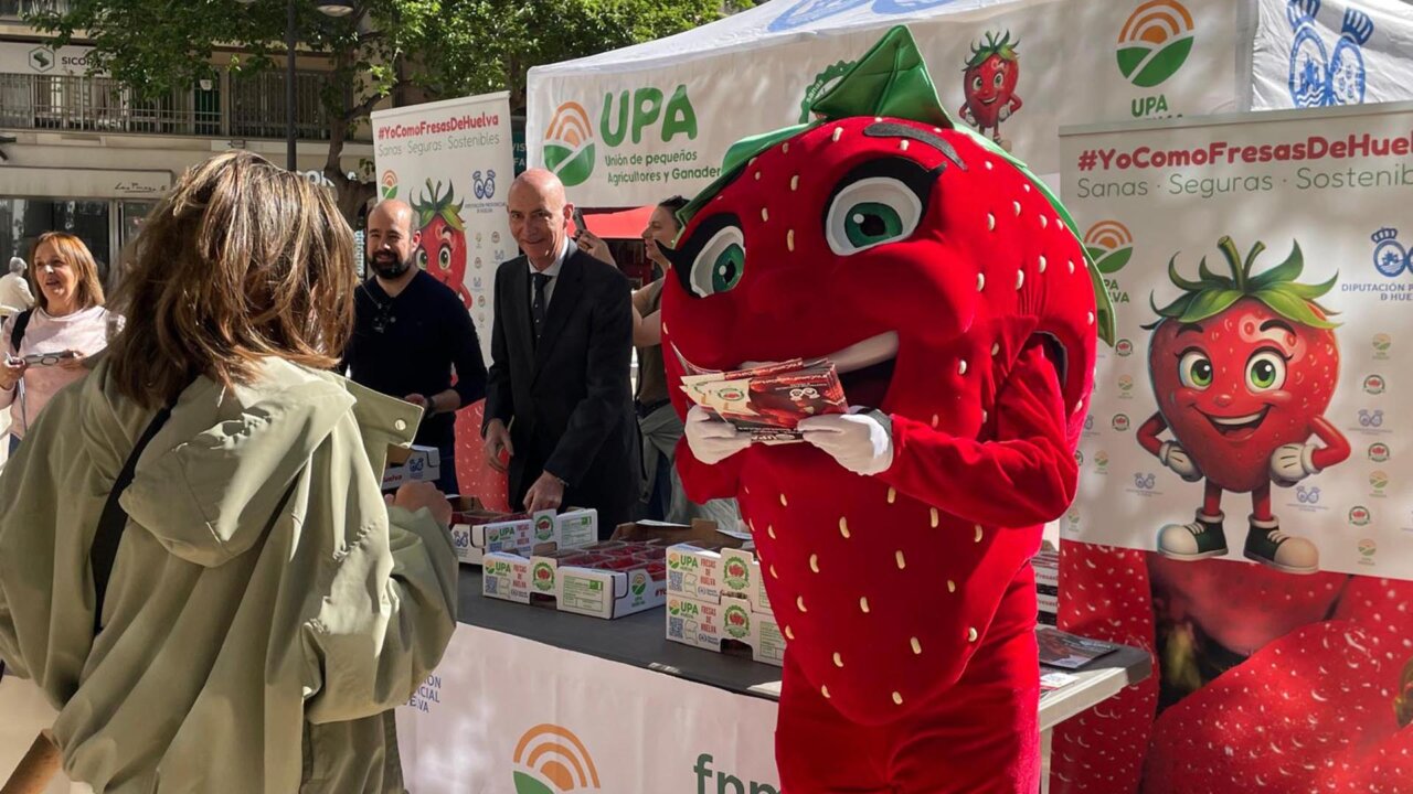 Evento de reparto de fresas de Huelva en Valencia con un personaje disfrazado.