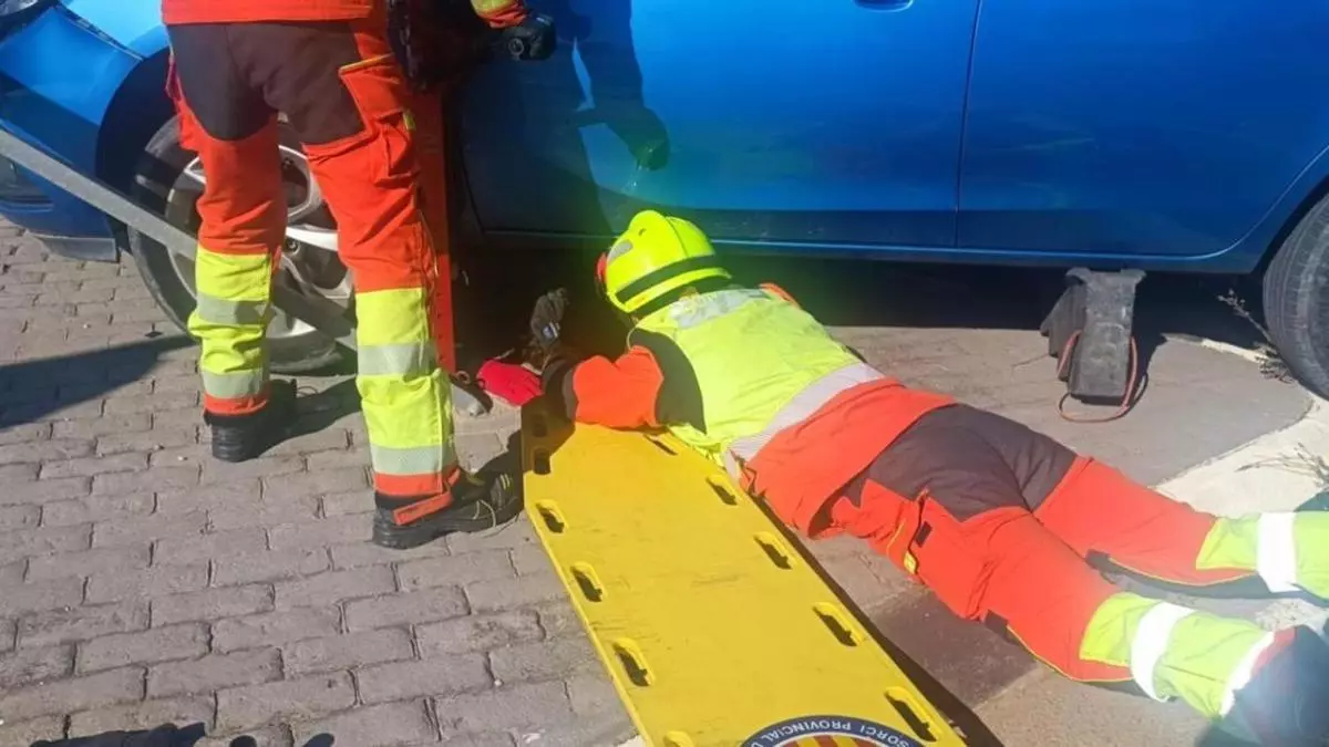 Bomberos realizando un rescate de un patinete atrapado bajo un coche en Torrent