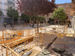 Trabajos de reurbanización en la plaza de Alaquas, Mislata con vallas de seguridad.