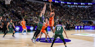 Jugadores de Valencia Basket en un emocionante partido contra Unicaja en Málaga.