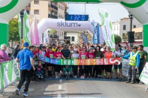 Participantes en la carrera RunCáncer en Paterna, con pancartas y ambiente festivo.