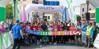 Participantes en la carrera RunCáncer en Paterna, con pancartas y ambiente festivo.
