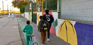 Niños caminando hacia la escuela por una ruta escolar señalizada